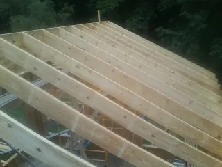 New roof rafters set over an addition before sheathing in Leicester